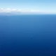 Vista aérea do imenso Oceano Pacífico sob um céu claro e azul, transmitindo a grandiosidade e a beleza natural do maior oceano do mundo.